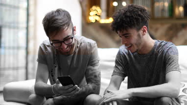 Two male friends looking at a smartphone