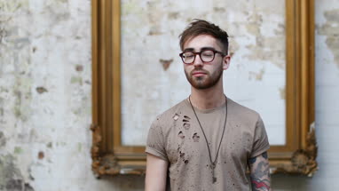 Young adult male turning to look at camera