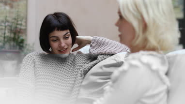 Young adult female friends chatting at home