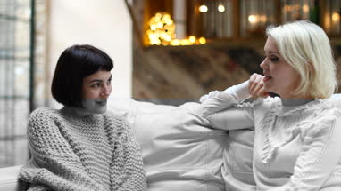 Young adult female friends chatting at home