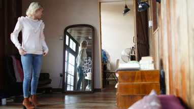 Young adult female looking at reflection in mirror
