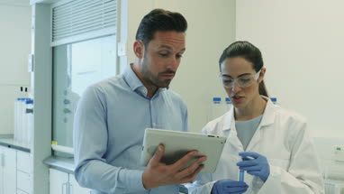 Female scientist discussing results of experiment with male colleague