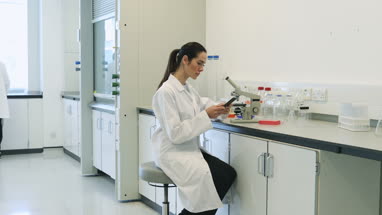 Female scientist using smartphone in laboratory