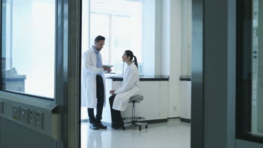 Female scientist discussing results of experiment with male colleague