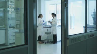 Two female scientists discussing results of experiment