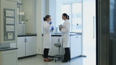 Two female scientists discussing results of experiment