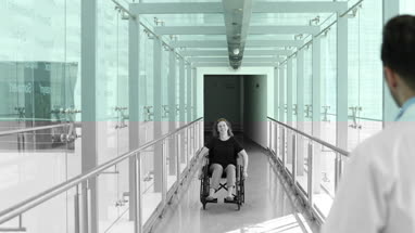 Woman in wheelchair greeted by medical professional