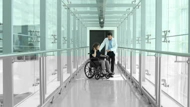 Woman in wheelchair discussing treatment with medical professional