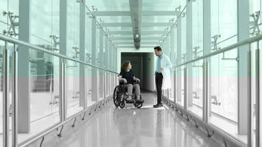 Woman in wheelchair discussing treatment with medical professional