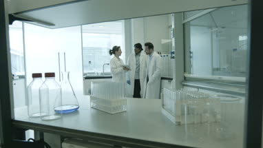 Team of scientists discussing experiment data on digital tablet