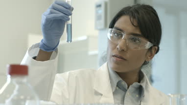 Female scientist analyzing test tube sample