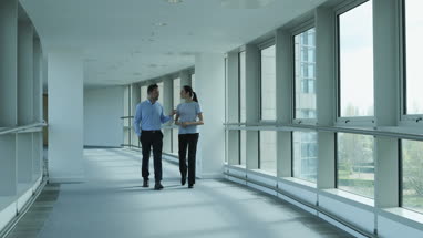 Colleagues walking through office in conversation