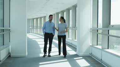 Colleagues walking through office discussing plans