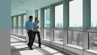 Colleagues looking out of office window on coffee break