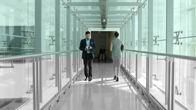 Business executives walking through busy office corridor