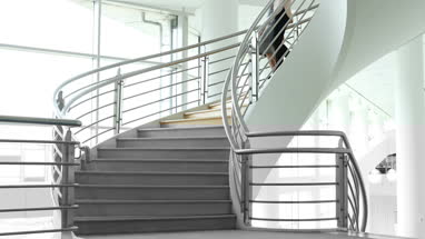 Female business colleagues walking down spiral staircase