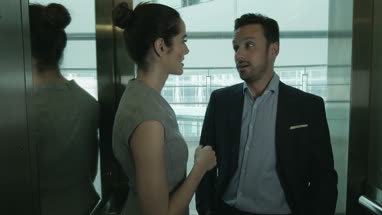 Business colleagues on way to a meeting in a glass elevator