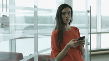 Female executive using smartphone waiting for a meeting