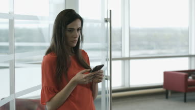 Female executive using smartphone waiting for a meeting
