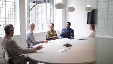Designer presenting virtual reality headset in a meeting