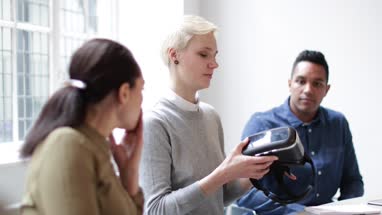 Designer presenting virtual reality headset in a meeting