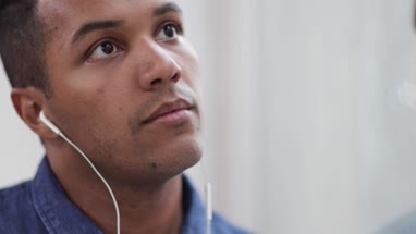 African American male listening to audio with headphones