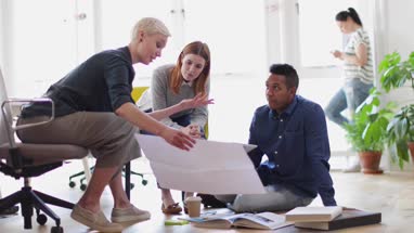 Colleagues looking at plans together in a meeting