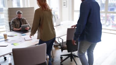 Colleagues looking at plans together in a meeting