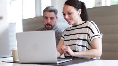 Coworkers looking at a laptop together