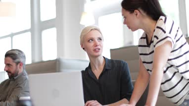 Manager training new employee in office