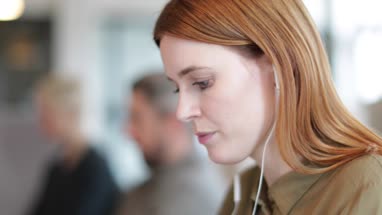 Businesswoman working on laptop with headphones