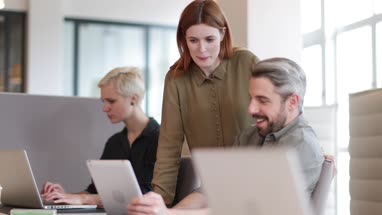 Coworkers looking at a laptop together