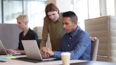 Manager training new employee in office