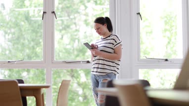 Businesswoman in office using smartphone and laptop