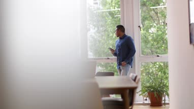 Businessman in empty office looking at smartphone