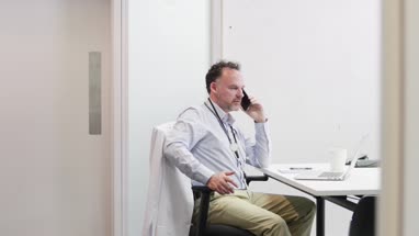 Male Medical Doctor on phone in his office