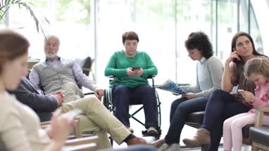 Patients waiting to be called in a crowded hospital waiting room 