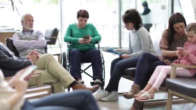 Patients waiting to be called in a crowded hospital waiting room 