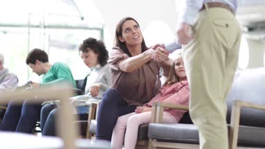 Mother and Child talking with Doctor in waiting room