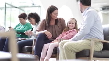 Mother and Child talking with Doctor in waiting room