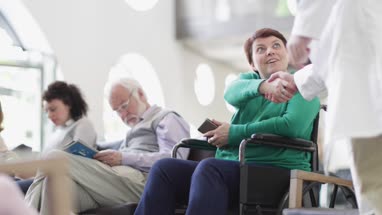 Disabled woman talking with Doctor in waiting room