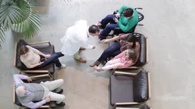 Overhead shot of Medical Doctor greeting Mother and Daughter in waiting room