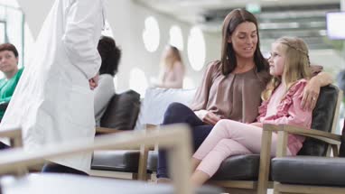 Mother and Child talking with Doctor in waiting room