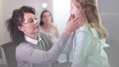 Female Medical Doctor checking a child's neck glands