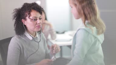 Female Medical Doctor listening to child's heartbeat