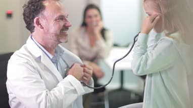 Male Medical Doctor listening to child's heartbeat