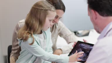 Family Doctor showing Mother and Daughter a Baby Ultrasound