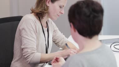 Female Medical Doctor taking an overweight patients blood pressure