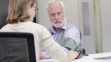 Female Medical Doctor taking a Senior patients blood pressure