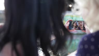 POV female friends taking selfie in urban city